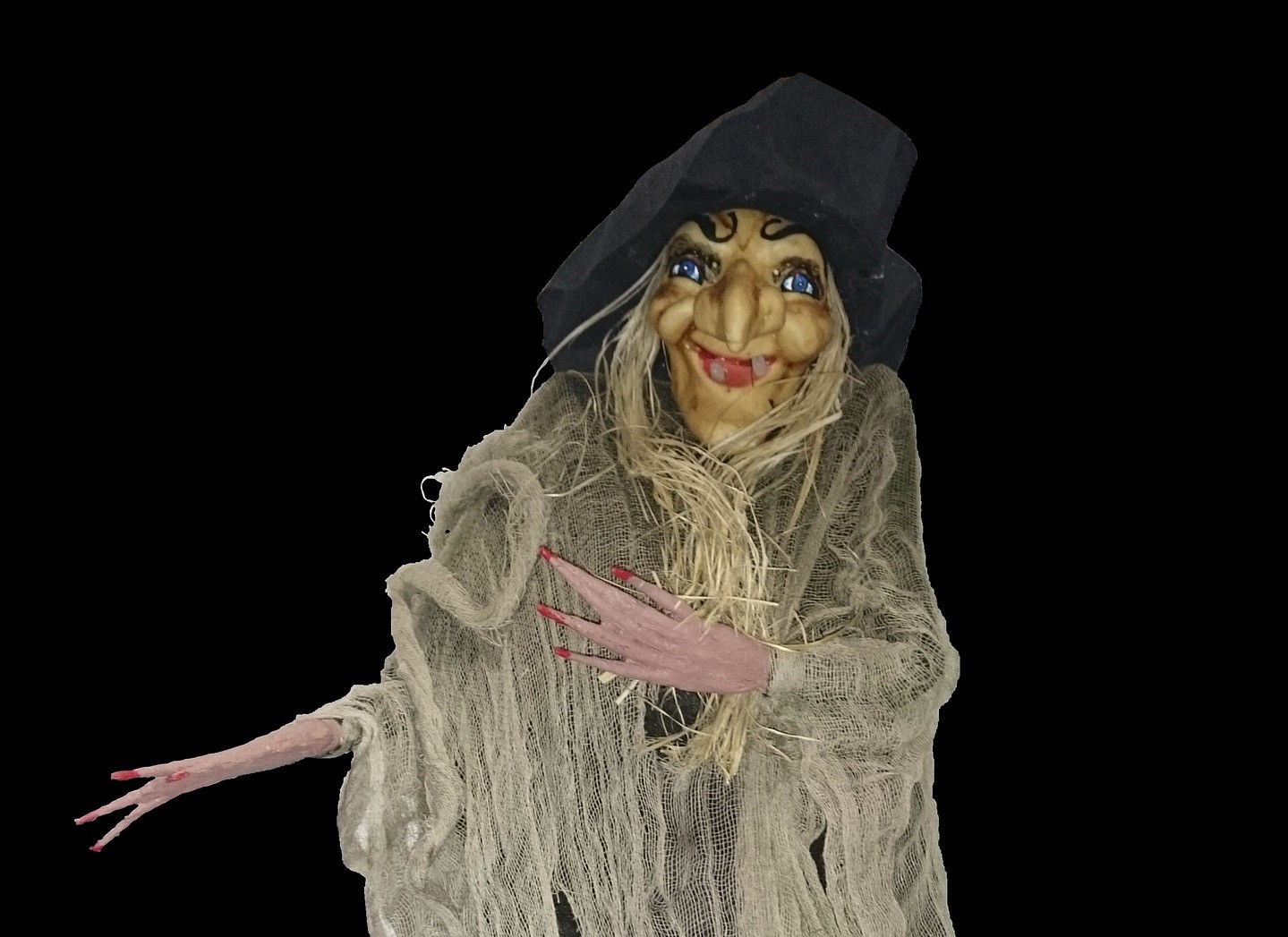 Una befana con cappello nero, naso lungo e acuto sdentata , mani con dita molto lunghe e scheletrite