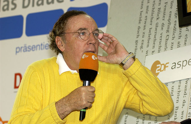 primo piano dello scrittore James Patterson con maglione giallo durante un intervista