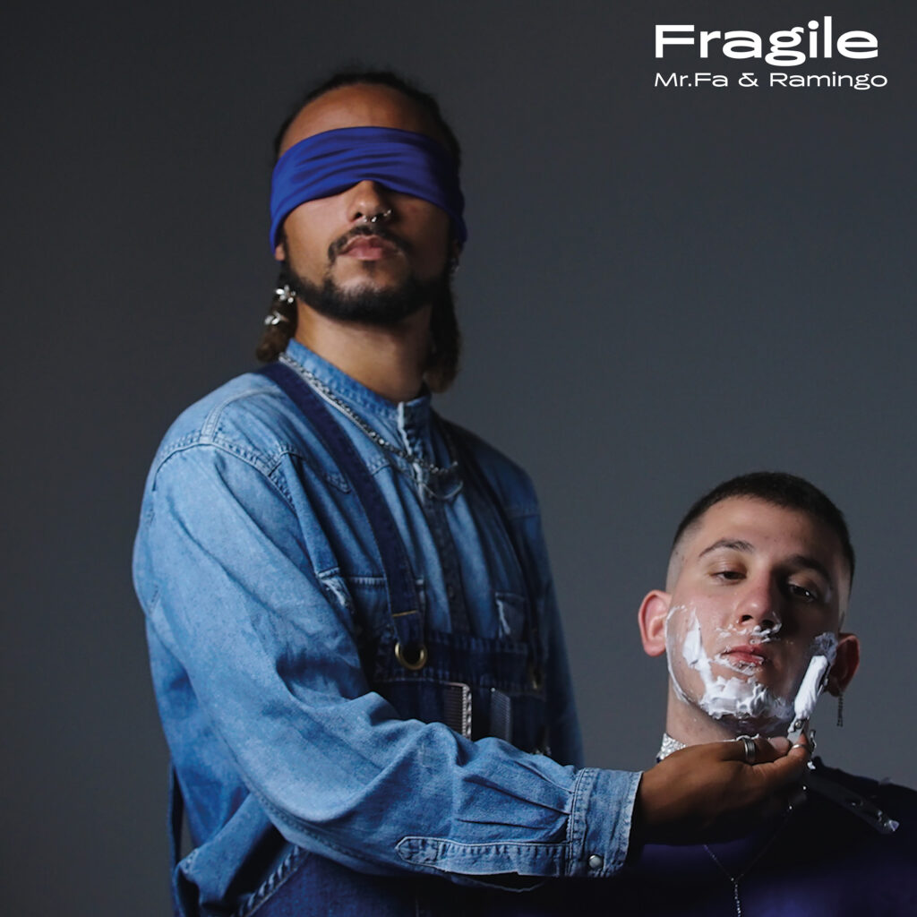 fragile - la copertina del singolo che vede mr fa, che indossa una camicia di jeans e una benda blu sugli occhi, fare la barba a ramingo seduto al suo fianco