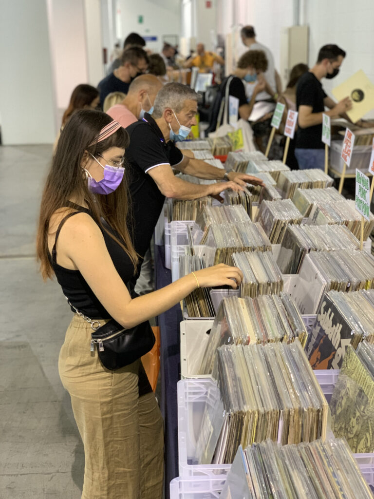 Il vinile - nella foto tante persone stanno guardano l'esposizione di box con dentro tanti vinili