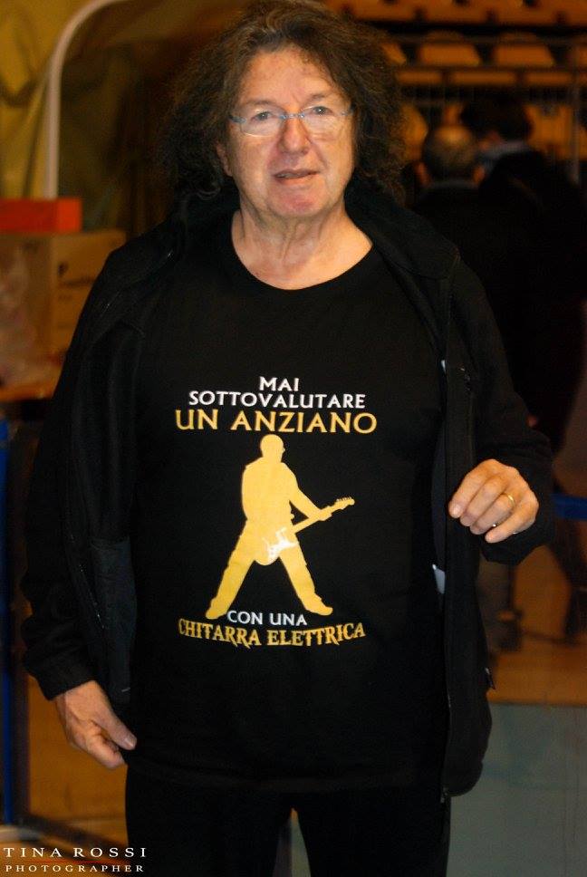 alberto radius indossa una t shirt nera con su scritto "mai sottolalutare un anziano con la chitarra elettrica"