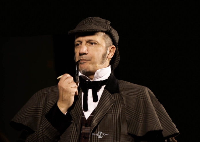 Sherlock holmes - L'attore mauro villata nei panni del celebre investigatore, ha il cappello a doppia visiera e la pipa in mano