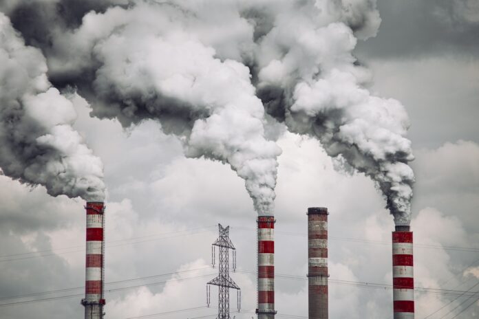 emergenza smog inquinamento - nella foto delle ciminiere a strisce rosse e bianche sputano fumo inquinante