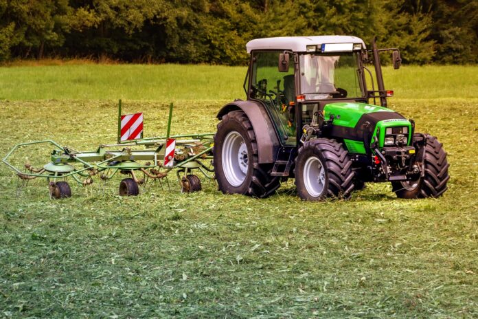 Crisi fertilizanti - nella foto un trattore verde in mezzo ad un campo da coltivare