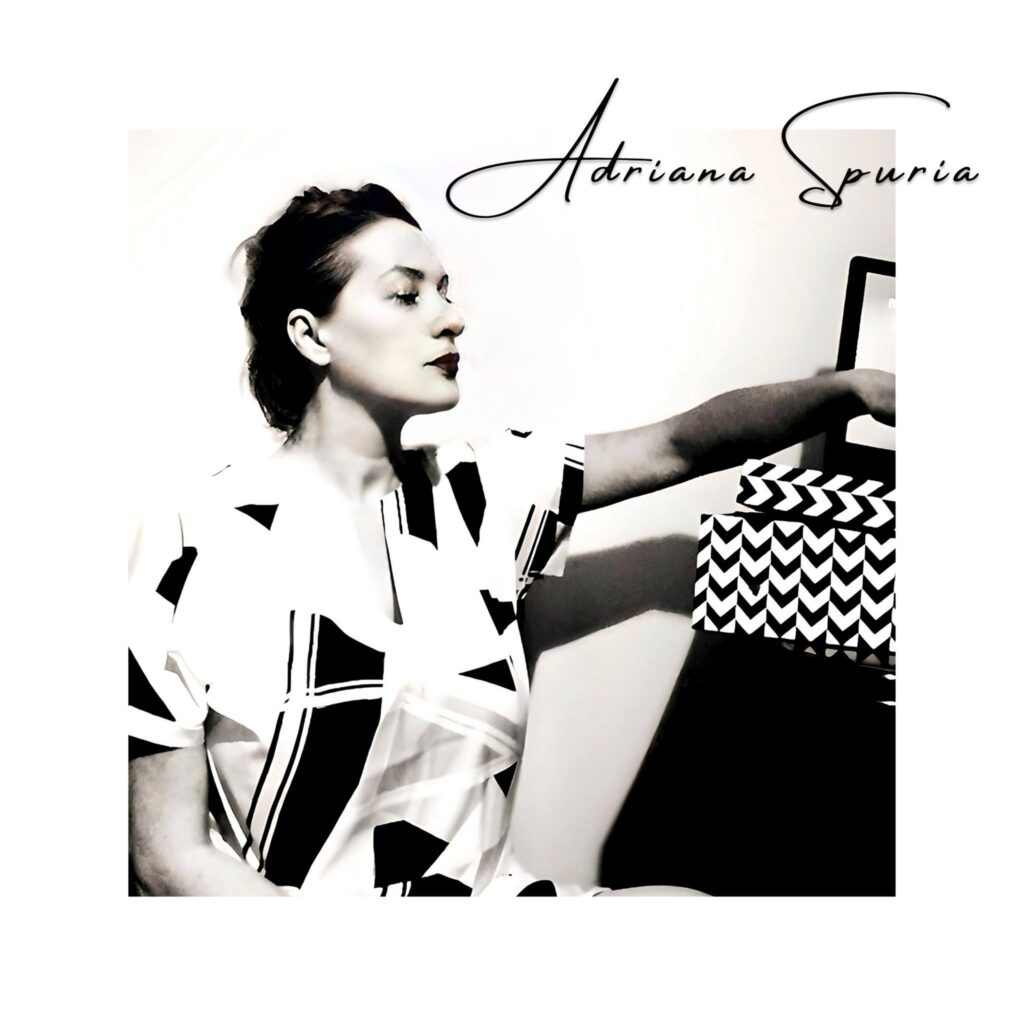 adriana spuria - la copertina del nuovo album. foto in bianco e nero che  la ritrae di profilo con il braccio sinistro appoggiato a un mobile