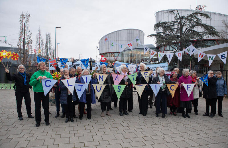 Svizzera - delle donne anziane di forte al Parlmento europeo tengono in mano dei cartelli con delle lettere che formano le parole "climate justice"
