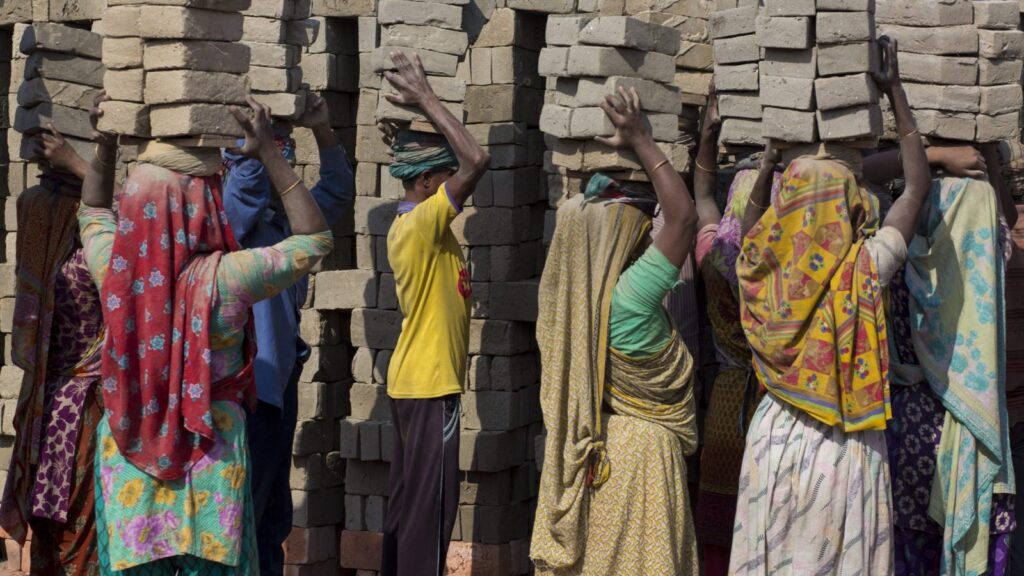 donne in condizione  di schiavitù moderna lavori forzati con mattoni in testa
