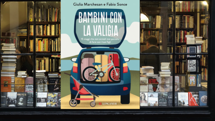 una libreria con in vetrina il libro bambini in valigia