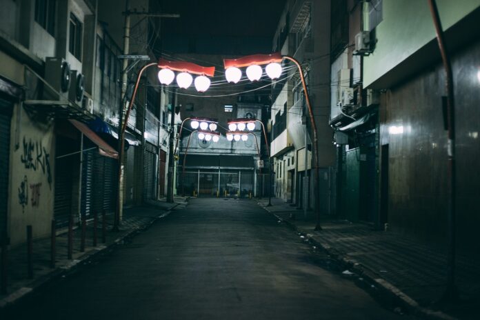 marciapiedi - la foto di una via stretta e buia, illuminata dalla luce dei lampioni