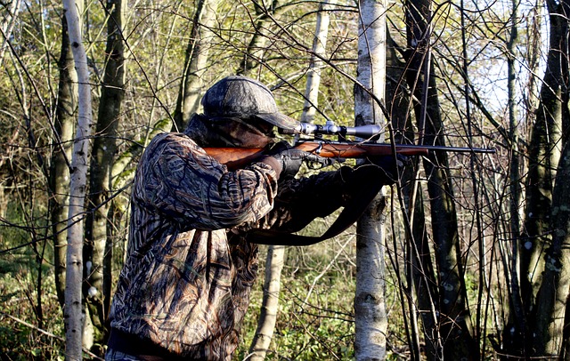 Un cacciatore sta puntando un animale con il fucile ed è in mezzo ad un bosco