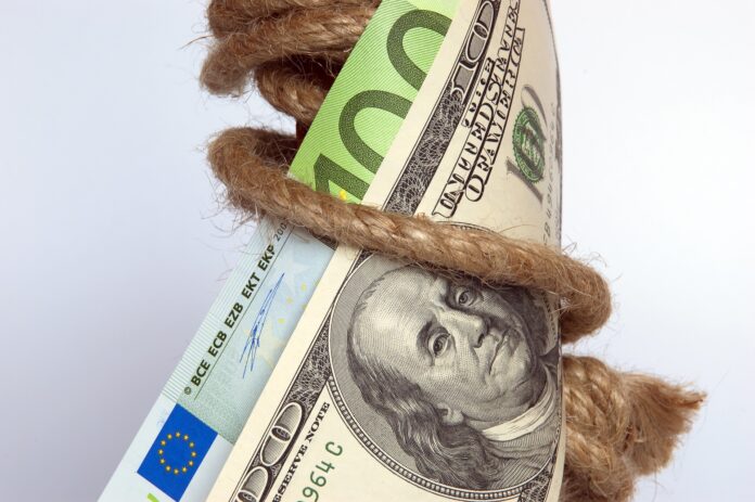 investimenti greeb - una banconota da 100 euro e una da 100 dollari legte con una corda