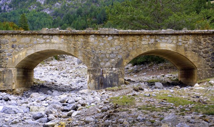 Pianura Pafdana siccità - un fiume in secca, due archi dove dovrebbe esserci un fiume che passa e invece ci sono solo sassi bianchi