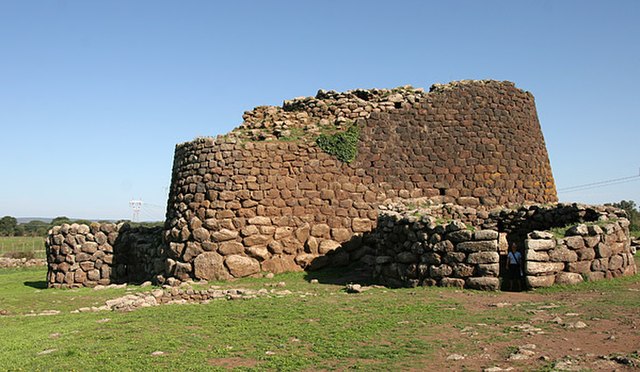 resti di nuraghe in primo piano in sardegna con prato intorno