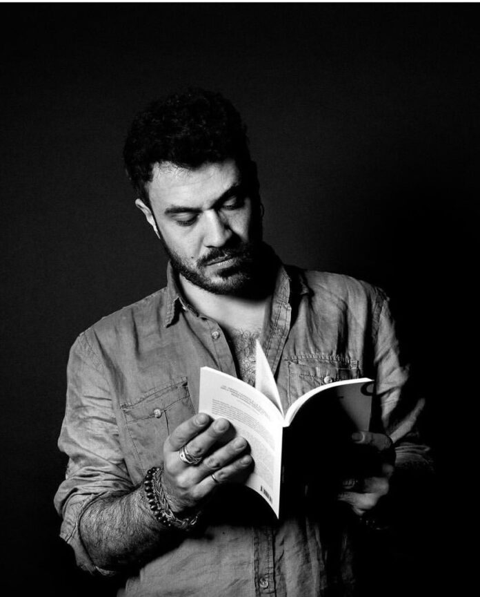 Gianluca Purgatorio, intervista, realtà, social, razionale, tecnologia, scrittore . Foto in bianco e nero che ritrae lo scrittore in primo piano mentre legge un libro.