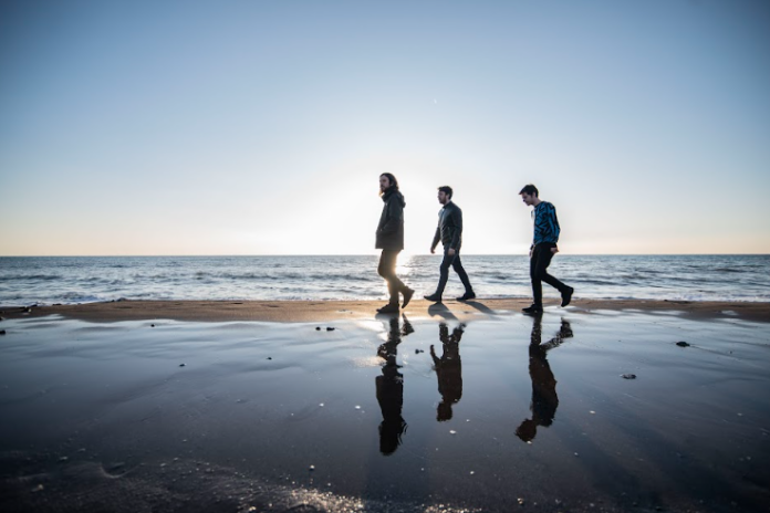 hofmann orchestra - i tre componenti la band fotografati mentre camminano sulla spiaggia