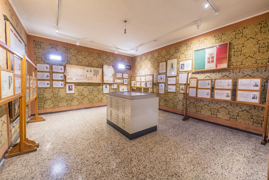Museo storico della Liberazione una sala con foto appese, quadri e in mezzo una teca