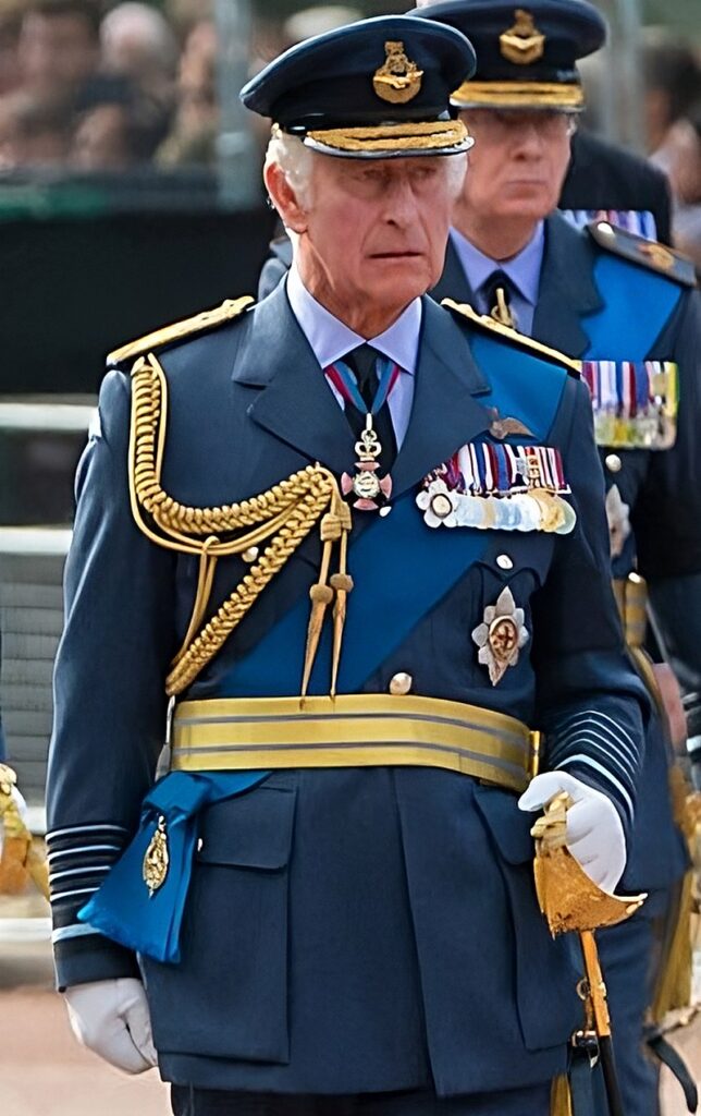 Re Carlo III durante i funerali di Elisabetta con uniforme bli e spada in piedi