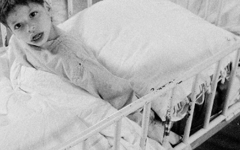 un bambino nel letto di Villa Azzura scatto del 1970 bianco nero