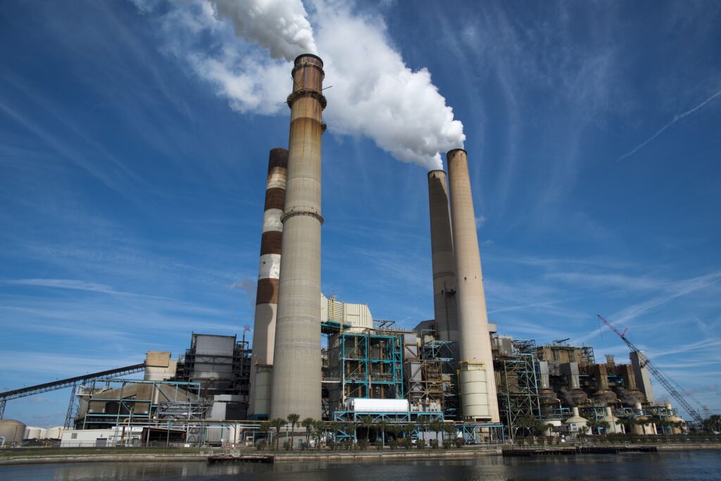 finanziamenti pubblici a combustibili fossili - nella foto una fabbrica di energia elettrica con ciminiere altissime che sputano fumo