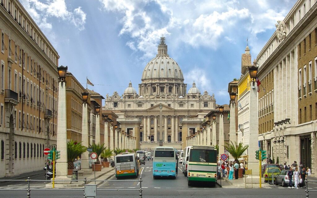 biglietto climatico - nella foto una veduta di via della conciliazione a Roma con la Basilica di San Pietro al centro e parcheggiati lungo la via, tre autobus