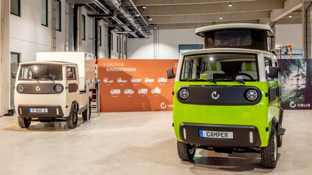 dei veicoli elettrici uno verde e uno marrone in un hangar