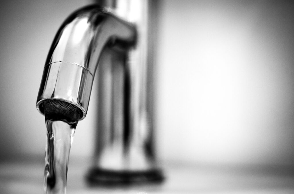 emergenza ambientale in Lombardia, dell'acqua potabile scorre da un rubinetto di casa (foto in bianco e nero)