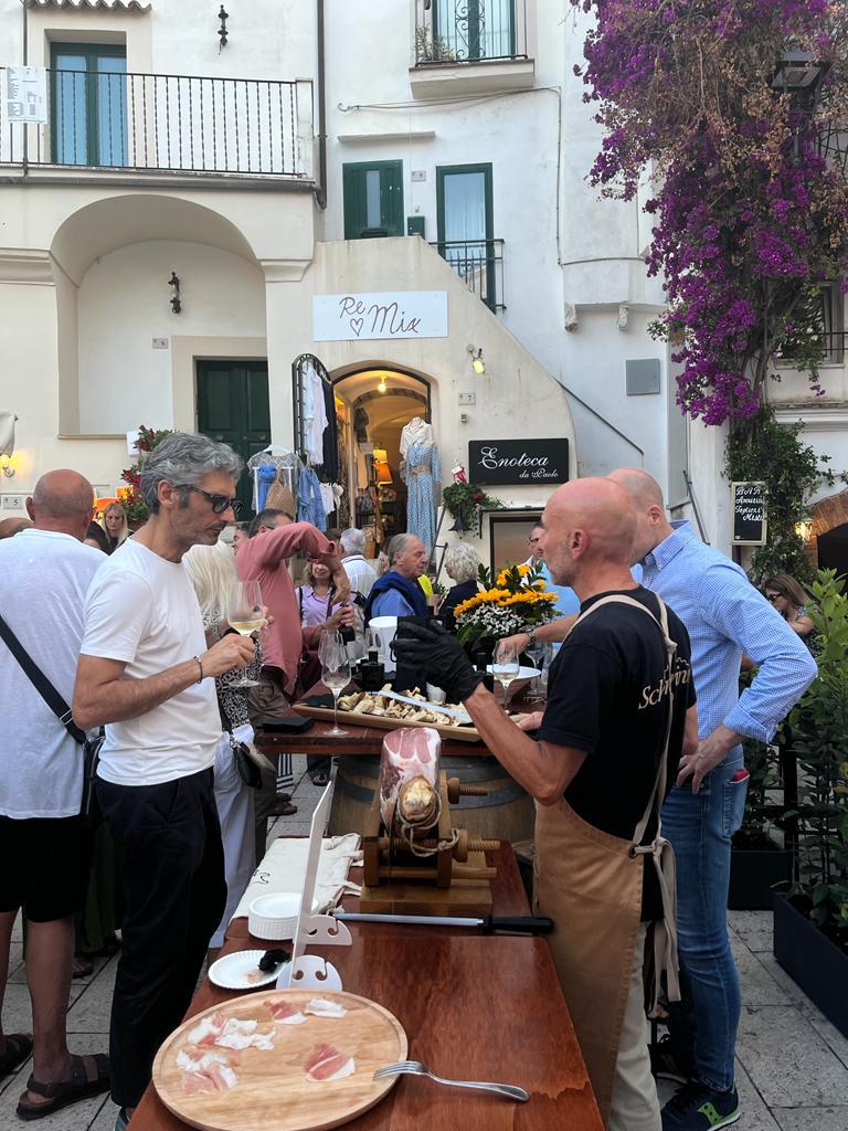 Sperlonga - delle persone in piazza mangiano e bevono in piedi lungo un tavolo