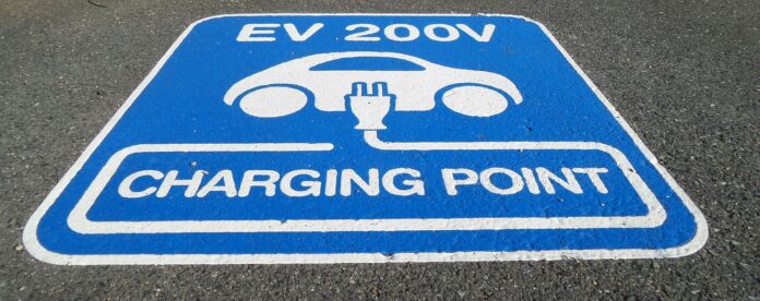 fondi PNRR per colonnine auto elettriche, nella foto il simbolo di un'auto con un aspina elettrica, disegnate per terra in un rettangolo blu