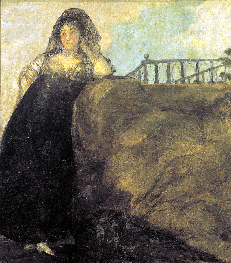 immagine della ragazza compagna di goya in piedi con costume ottocentesco gonna nera e camicia impero bianca