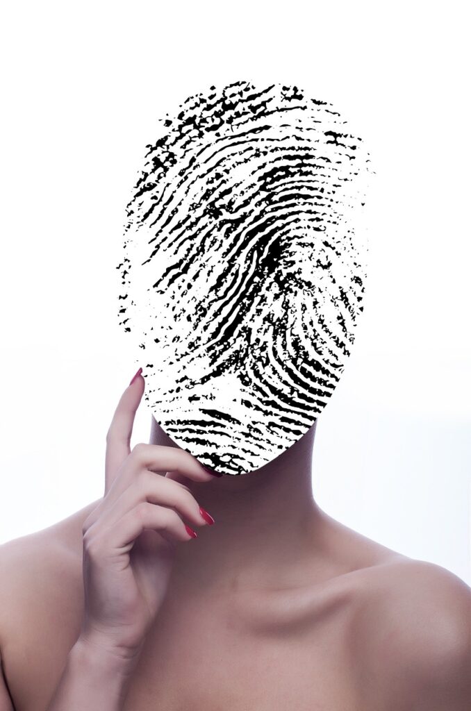 protezione dei dati personali - nella foto il mezo busto di una donna con le spalle nude che alza la mano con l'indice alto e al posto del viso ha un'impronta digitale