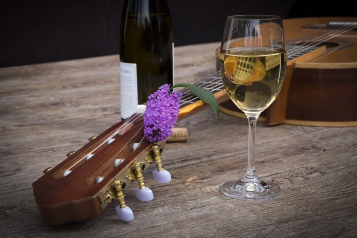 vini tipici monferrato on stage - nella foto un bicchiere di vino bianco, una chitarra appoggiata e un rametto di lavanda