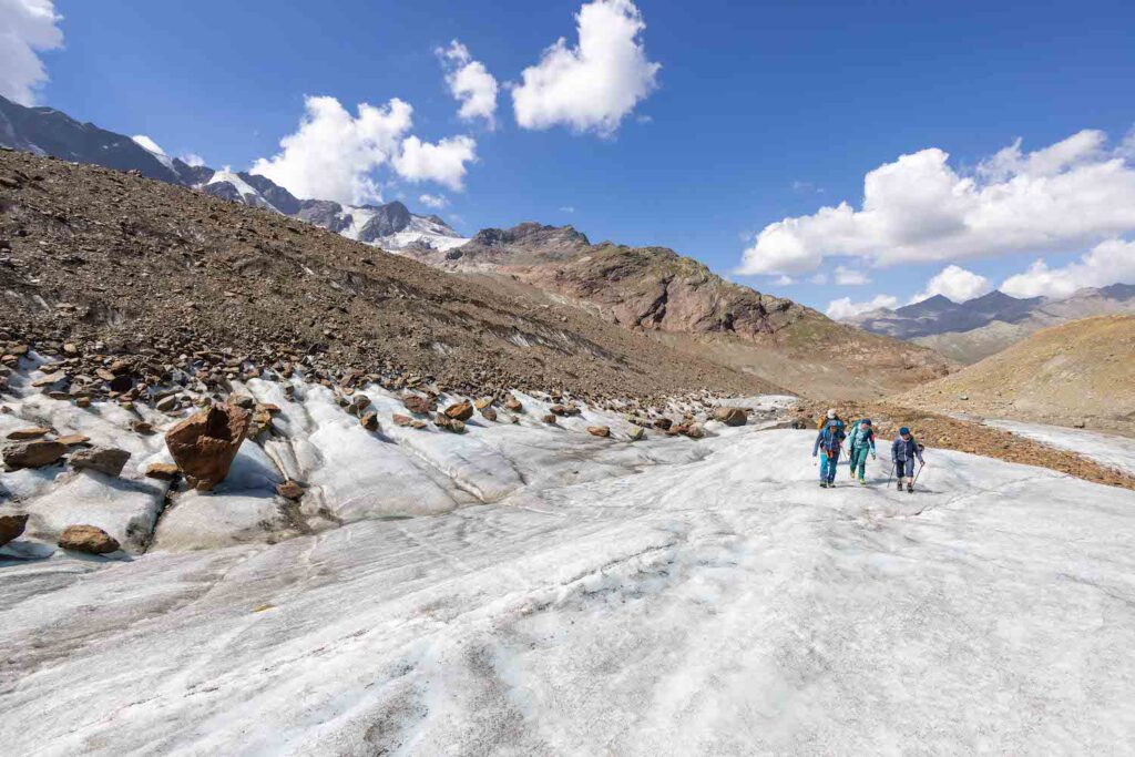 ghiacciaio dei Forni in Valtellina - pochissimo ghiaccio e le vette sono aride di terra, sulla sinistra, un gruppo di esperti che sta monitorando il terreno