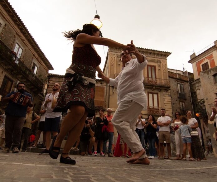 una coppia balla la tarantella in piazza