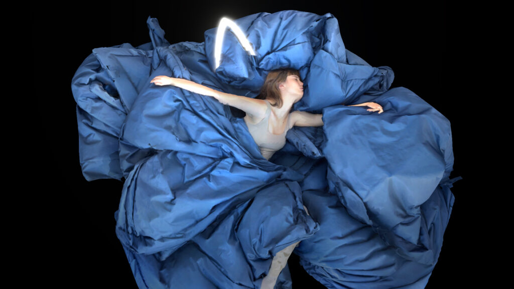 metaverso - una donna è sdraiata con braccia e gambe allargate ed è avvolta da un tessuto azzurro che sembra una nuvola