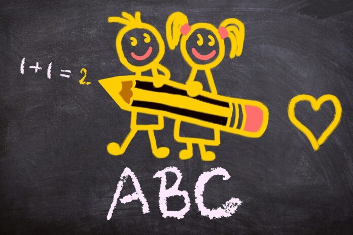 Rientro scolastico anno accademico 2023 - nella foto una lavagna nera con sopra disegnati in giallo due bambini, un maschio e una femmina, che tengono in mano una grossa matita. Sotto di loro la scritta in bianco 