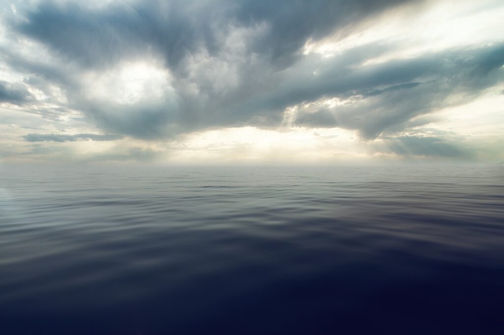 onde anomale e nubi improvvise - delle nuvole minacciose sul mare illuminato da una cupa luce gialla e grigia
