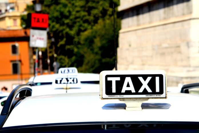 radiotaxi - nella foto si vede il tettuccio di un'auto bianca con l'insegna taxi