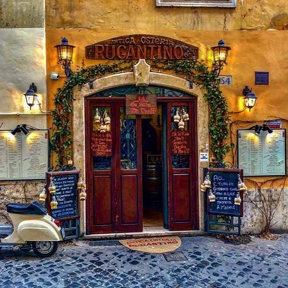 Cucina tipica romana - la porta d'ingresso del locale, fatta in legno con tanti fiaschi di vino d'epoca esposti fuori 