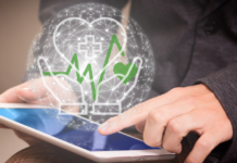 Fascicolo Sanitario Elettronico - in primo piano un tablet con sopra una sfera trasparente in cui si vedono disegnate due mani aperte che proteggono un cuore con all'interno una croce simbolo della salute e in verde un tracciato tipo ellettrocardiogramma che termina con un cuore verde