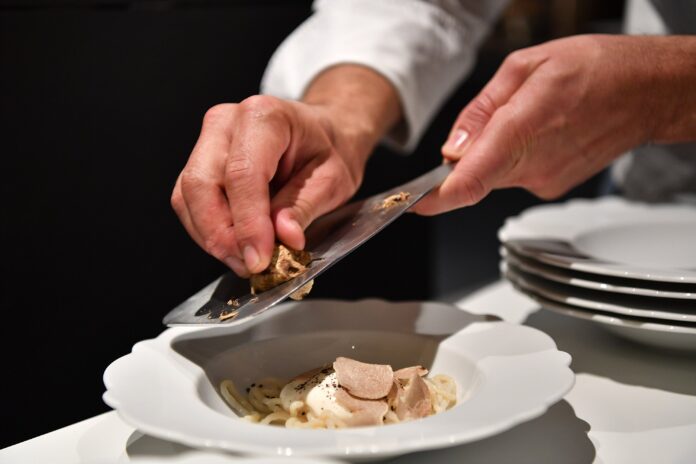 Tartufo d'Alba grattuggiato da uno chef su un piatto