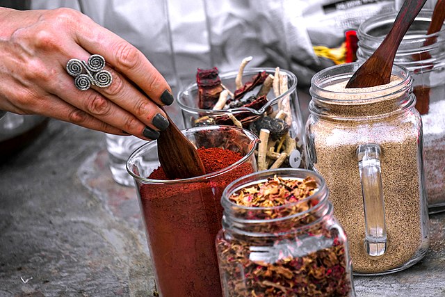 ayurveda mano di donna con anello e tatuaggio indiano con spezie e aromi naturalidi 