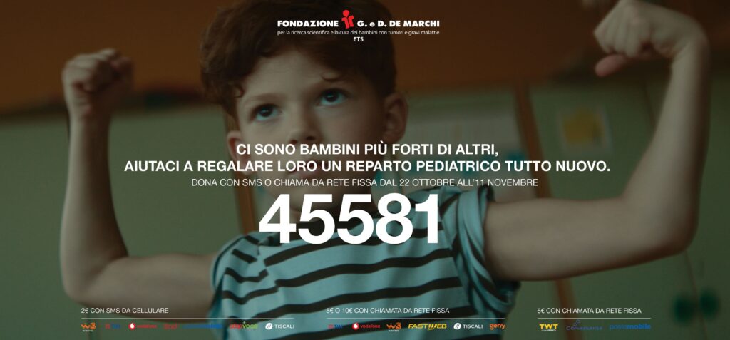 Un ospedale mica male - la pubblicità della raccolta fondi con un bambino che alza le braccia con i pugni chiusi, in segno di forza. Il bimbo indossa una maglietta verde con righe orizzontali nere