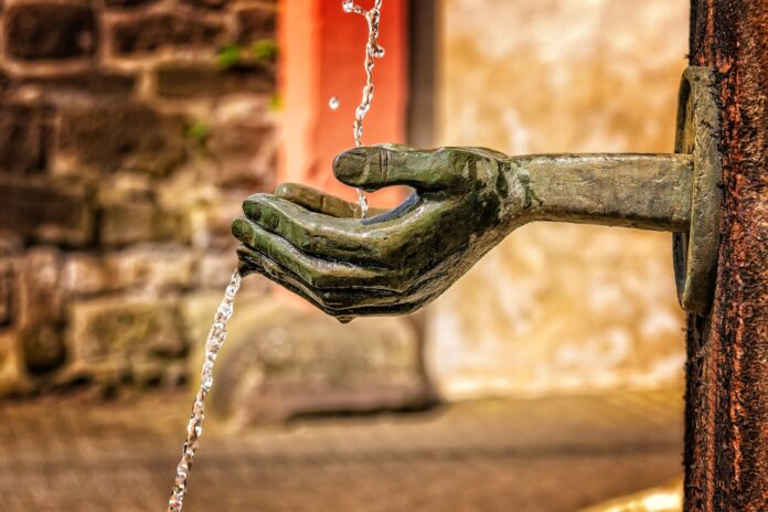 Giornata Mondiale dell'alimentazione - fao - una fontana con due mani di legno nelle quali confluisce un getto d'acqua