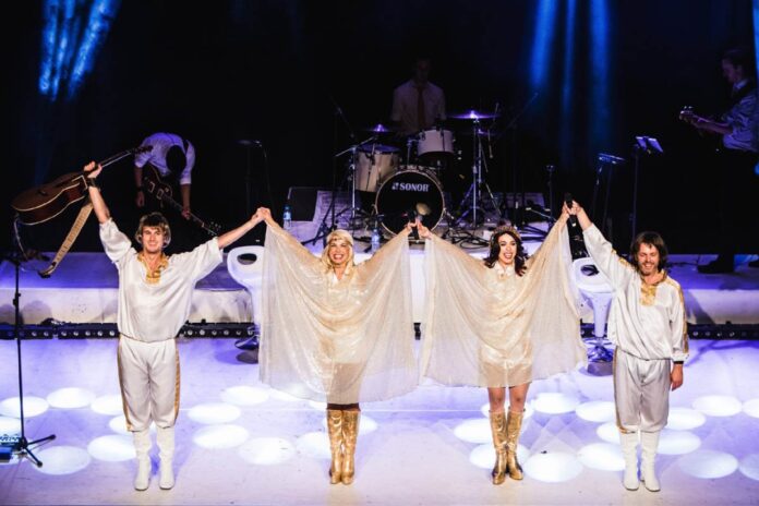 mania Abba the tribute immagine di scena in palco con tutti i protagonisti in vesti bianche presa dall'alto