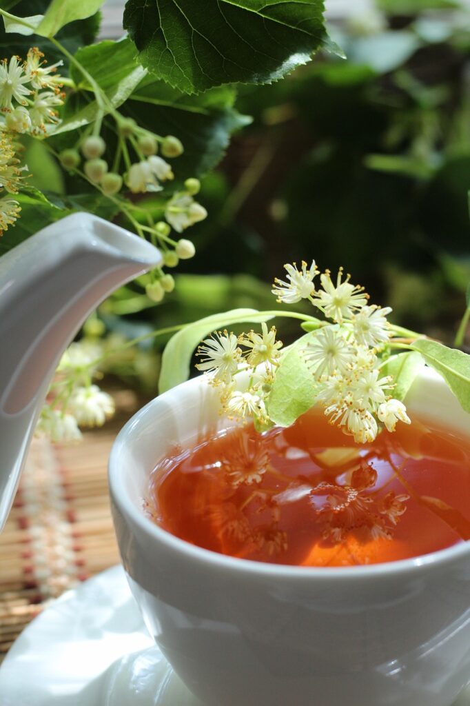 tazza da tè di porcellana bianca con teeira bianca e infuso di tiglio all'interno