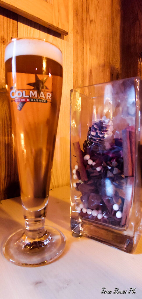 un boccale di birra appoggiato ad un tavolino con affianco una pgna natalizia
