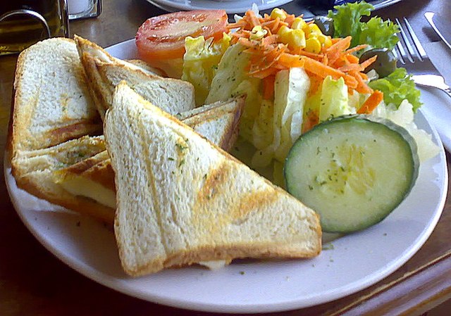 un toast tagliato su un piatto con verdure cetriolo e carote