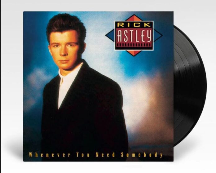 rick astley - la copertina dell'album whenever you need somebody, che lo ritrae in primo piano, con indosso una camicia bianca e una giacca nera