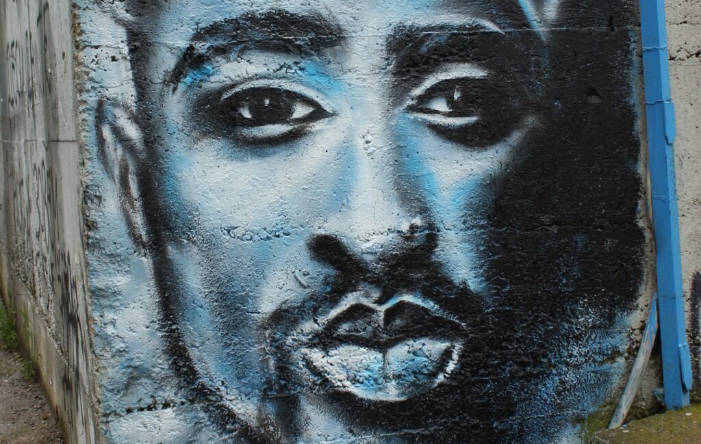 tupac - un graffiti con il volto di tpac, uomo di colore, con baffi e pizzetto neri