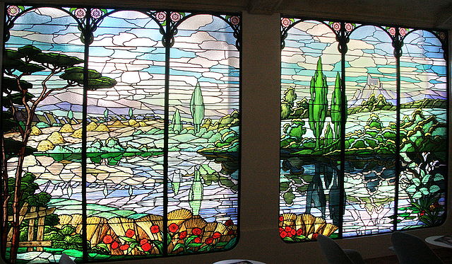 vetrate colorate presenti in casa Garriga Nogués con raffigurato un paesaggio collinare con cipressi, la casa ospita il Museo dell'arte Proibita